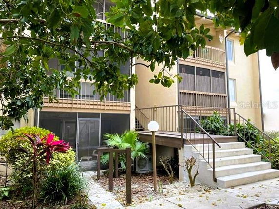 Front view of a multi-story building with balconies and a staircase.