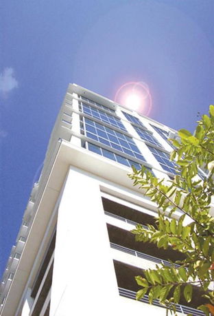 Upward view of a multi-story building with glass windows.