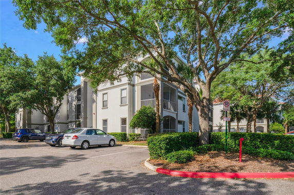 Front view of a multi-story residential building with parking area.