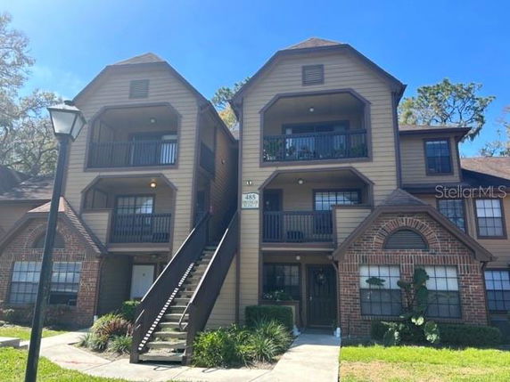 Front view of a multi-story residential building with brick accents and exterior staircases.