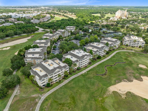 Aerial view of multiple residential buildings surrounded by green spaces and golf courses.
