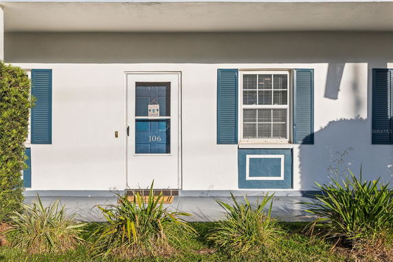 Front view of a house with a white door and blue shutters.