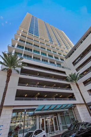 Front view of a high-rise building with multiple balconies and glass facade.