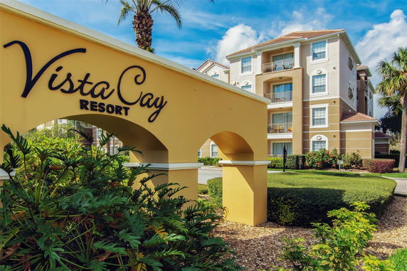 Front view of a resort building with multiple balconies and palm trees.