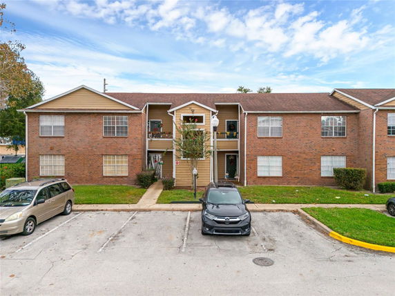 Front view of a two-story apartment building with a brick facade and multiple windows.
