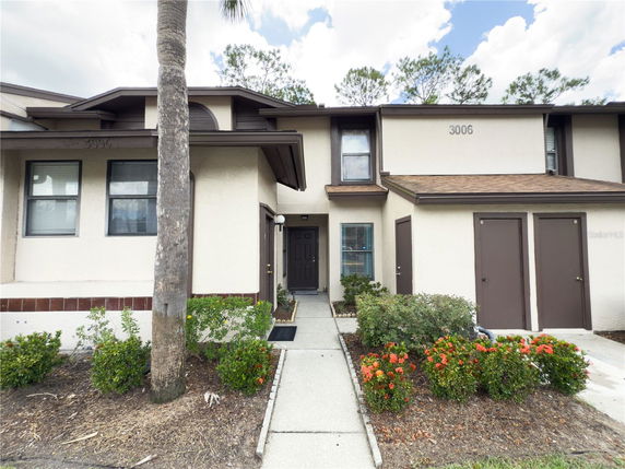 Front view of a two-story residential building with a tan exterior and brown trim.