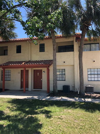 Front view of a two-story building with tiled roof and multiple windows.