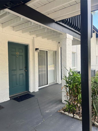 Front view of a house with a teal door and a covered entryway.