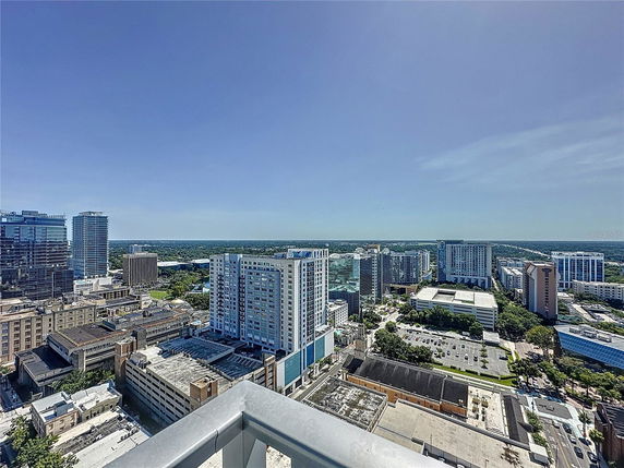 Panoramic view of a cityscape with multiple high-rise buildings under a clear blue sky.