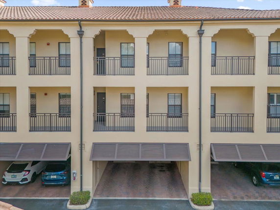 Front view of a multi-story building with multiple balconies and covered parking.