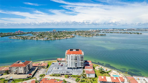 Panoramic view of a coastal area with a high-rise building and waterfront scenery.