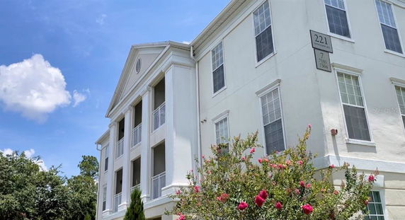 Front view of a multi-story building with white exterior and balconies.