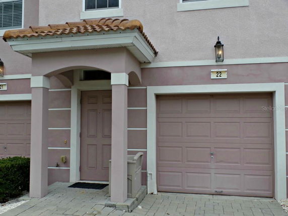 Front view of a house with a garage and an arched entryway.