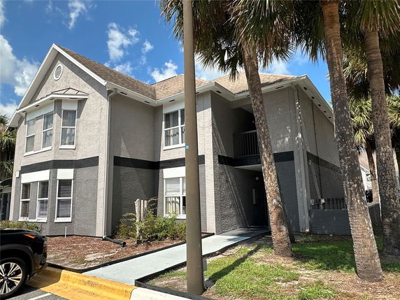 Front view of a two-story house with a gable roof and multiple windows.
