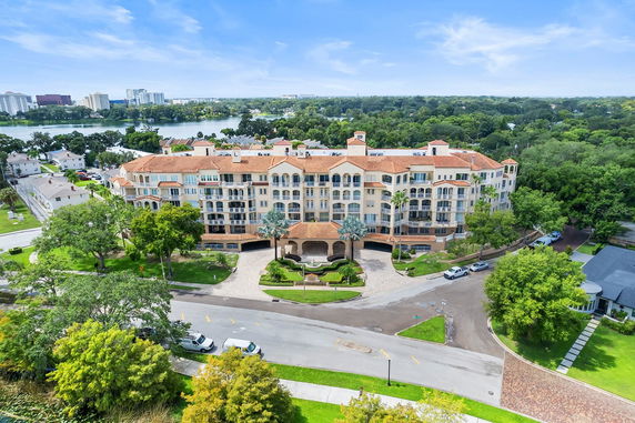 Front view of a multi-story residential building with a red-tiled roof and multiple balconies.