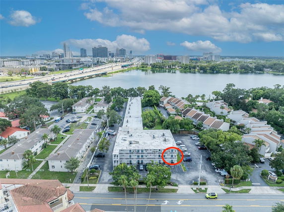 Panoramic view of a residential area near a body of water with multiple buildings and roads.