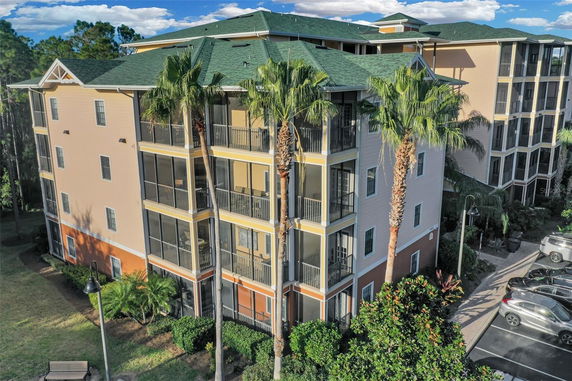 Front view of a multi-story residential building with balconies and a green roof.