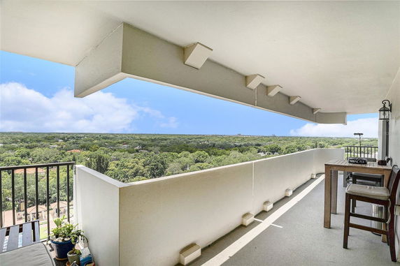 Panoramic view from a building balcony overlooking a green landscape.