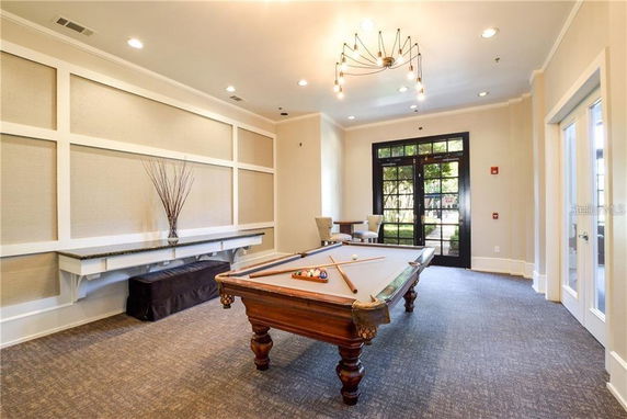 Room featuring a billiards table with seating and decorative lighting.