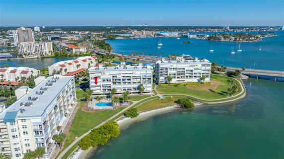 Panoramic view of waterfront apartment buildings with water and cityscape in the background.