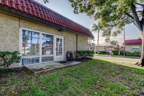 Front view of a building with a textured exterior and large windows, featuring a red tiled roof.