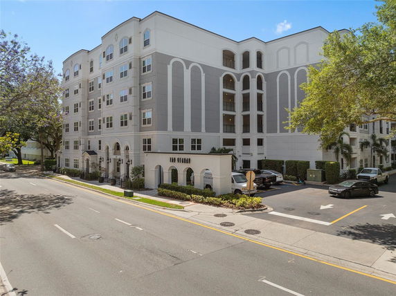 Front view of a multi-story building with arched windows and decorative facade.