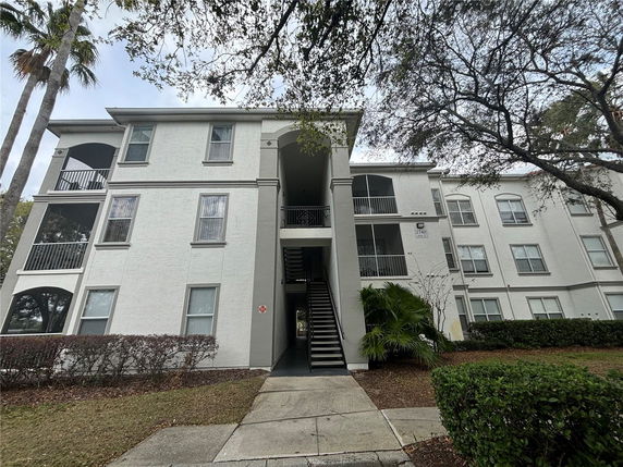 Front view of a multi-story residential building with balconies and stair access.