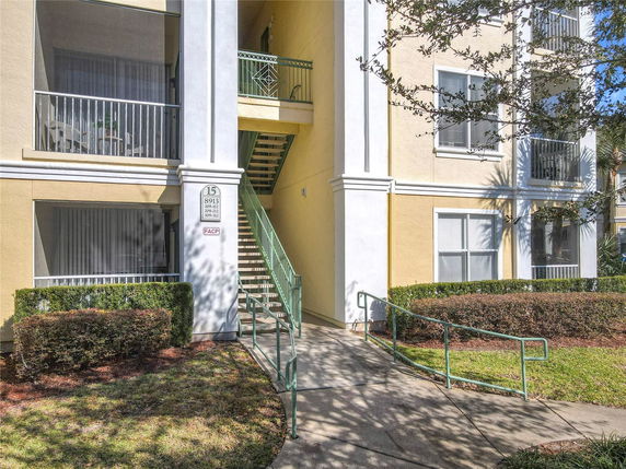 Front view of a multi-story residential building with balconies and exterior stairs.