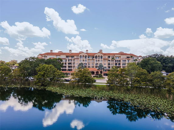 Front view of a large multi-story residential building with a red roof.