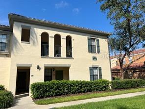 Front view of a two-story house with an upper balcony and arched openings.