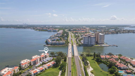Panoramic view of a coastal area with buildings and a highway over water.
