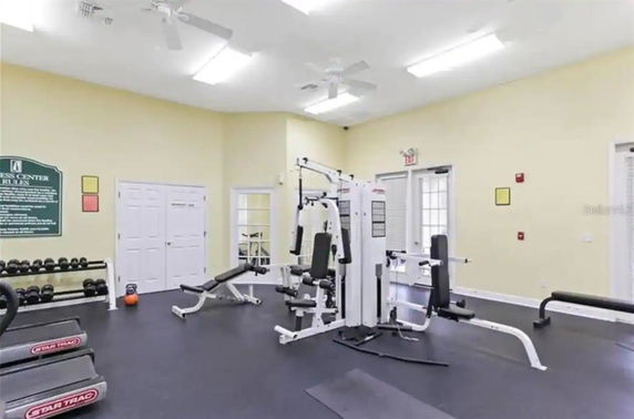 Indoor gym area with exercise machines and weights.