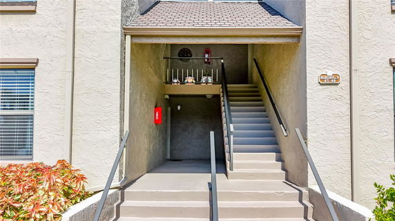 Front view of an apartment building entrance with stairs leading up.