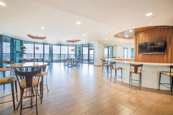 Spacious indoor recreation area with tables, chairs, and a TV.