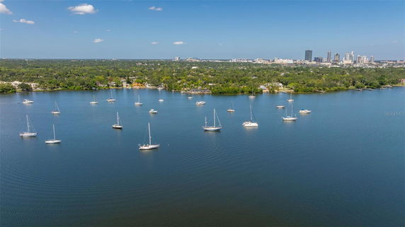 Panoramic view of a body of water with sailboats and a cityscape in the background.
