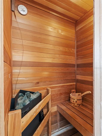 Interior of a wooden sauna room with a heater and a wooden bench.