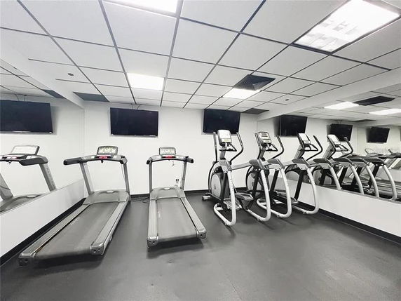 Indoor gym area with treadmills and elliptical machines.