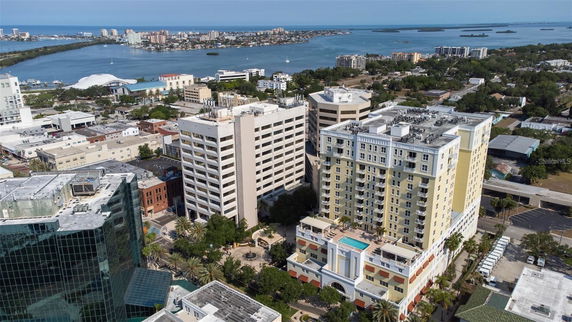 Aerial view of a cityscape with tall buildings near a waterfront.