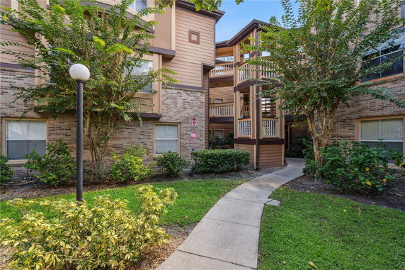 Front view of an apartment building with brick and wood facade.