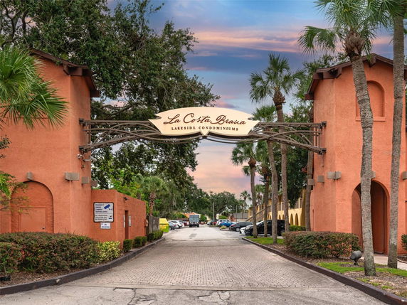 Entrance view of La Costa Brava Lakeside Condominiums with arched gateway.