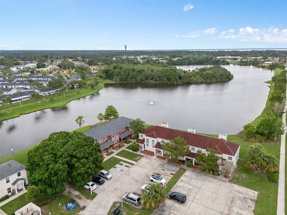 Aerial view of a residential area with a lake and surrounding homes.