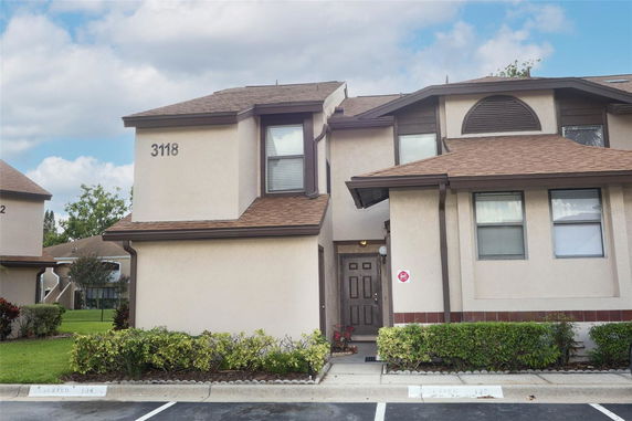 Front view of a two-story house with brown roof and beige walls.