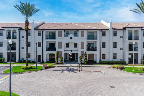 Front view of a multi-story residential building with balconies and a central entrance.