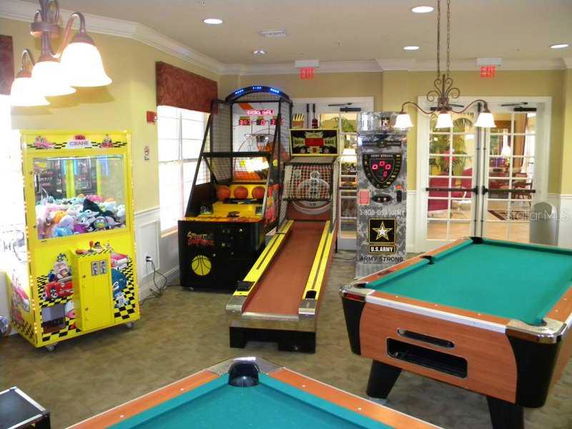 Indoor recreational area with arcade games and a pool table.