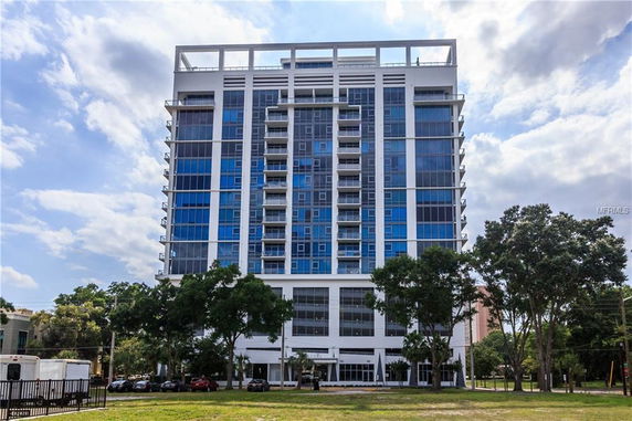 Front view of a multi-story glass building with balconies.