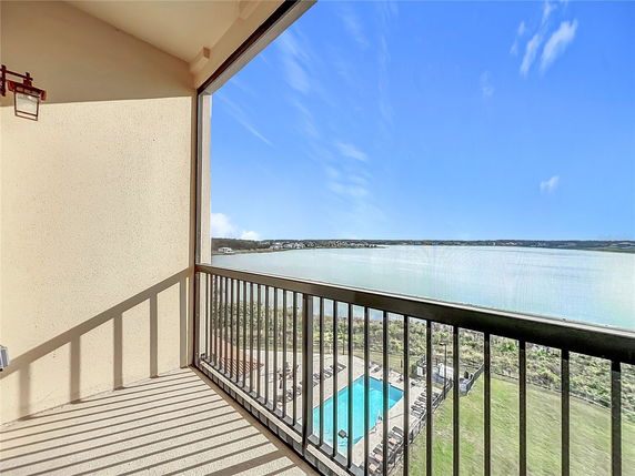 View from a balcony overlooking a large body of water and surrounding landscape.