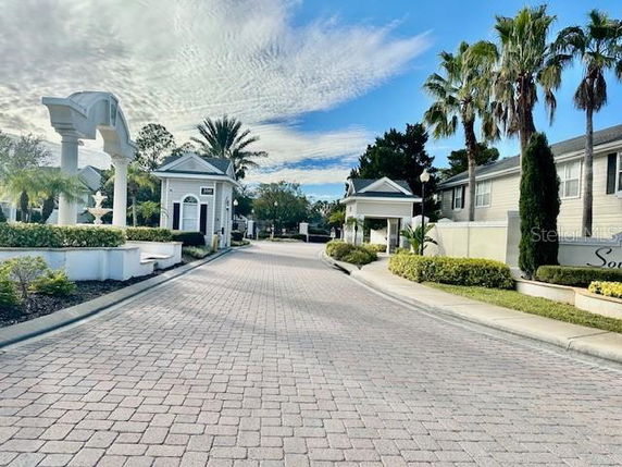 Front view of a residential entrance with columns and landscaped surroundings.