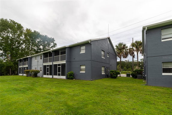 Front view of a two-story residential building with a screened porch.