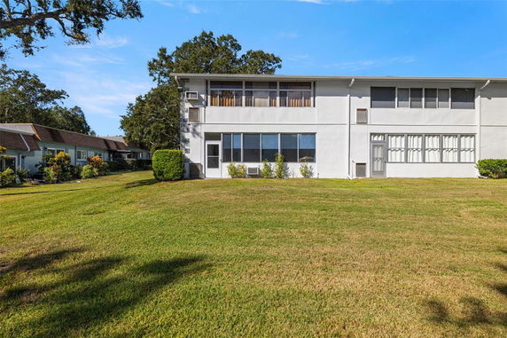 Front view of a two-story building with large windows and a flat roof.