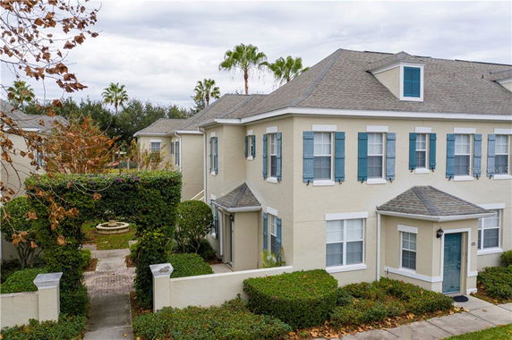 Front view of a multi-story house with blue window shutters.